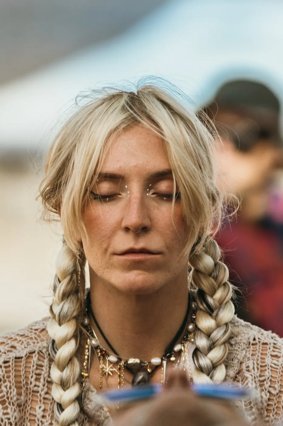 A woman with long braids, eyes closed, mid-meditation at the Oasis