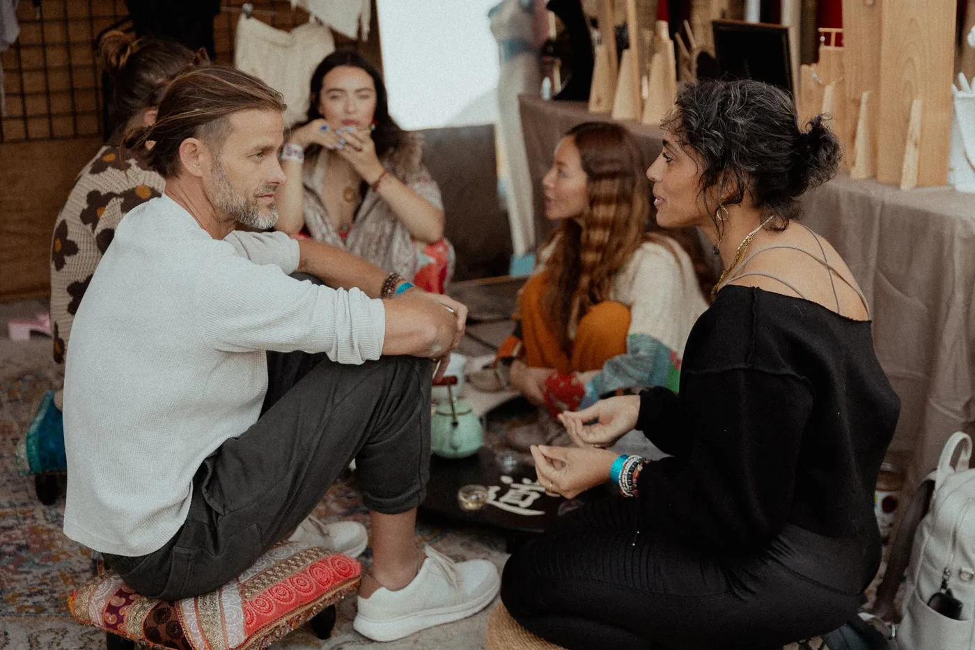 Small groups talking in a circle on cushions at a Press Pause workshop